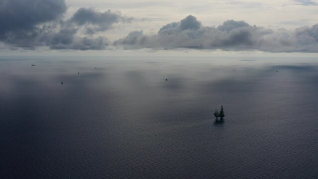 Jack up drilling rig and production platform in the middle of the ocean during couldy time
