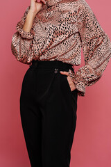 Nice woman in shirt and pants at pink background.
