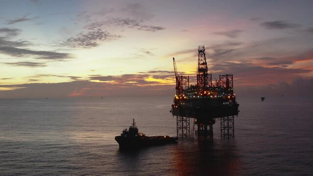 Jack up drilling rig and production platform in the middle of the ocean at sunrise time
