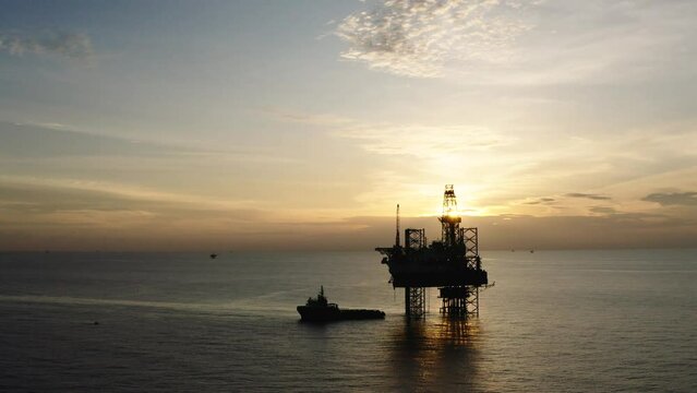 Jack up drilling rig and production platform in the middle of the ocean at sunrise time
