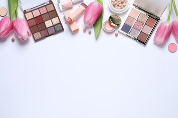 Flat lay composition with eyeshadow palettes and beautiful flowers on white background, space for...