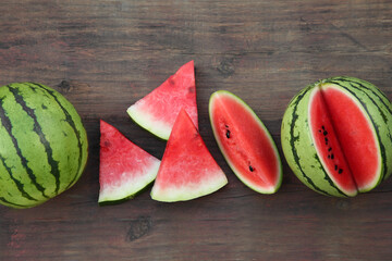 Delicious ripe watermelons on wooden table, flat lay