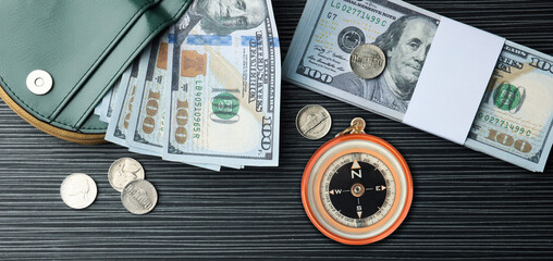 Exchange rate. Wallet, money (dollar banknotes and coins) and compass on wooden background, flat lay. Banner design
