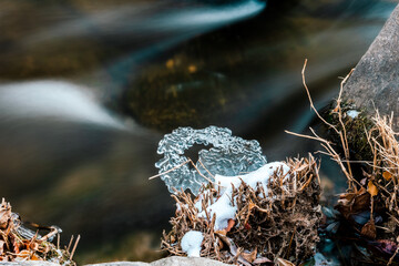 Landscape of a small river frozen in winter ice