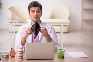 Young male dentist working in the clinic