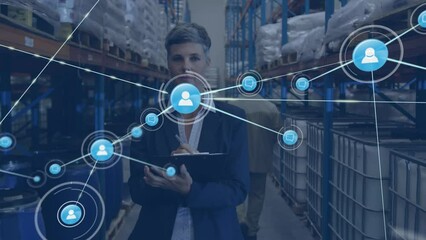 Animation of network of connections with icons over caucasian businesswoman working in warehouse - Powered by Adobe