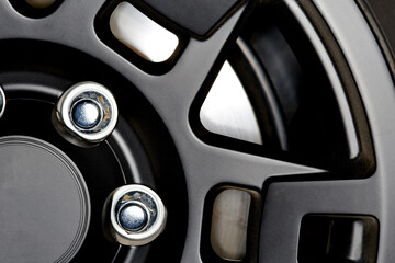 Close up of a Black Car Wheel Rim with Chrome Lug Nuts