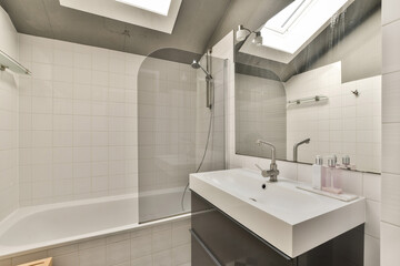 a bathroom with a sink, mirror and bathtub on the wall next to it is a skylight in the ceiling