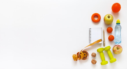 Healthy lifestyle concept. Diet plan. Activity and weight loss. Slimming for summer. Notepad, measuring tape, dumbbells, expander, massager, fruits, nuts and water on white background. Banner © Katvic