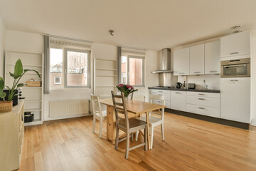 a kitchen and dining area in a small apartment with wood floors, white cabinets and an oven on the wall