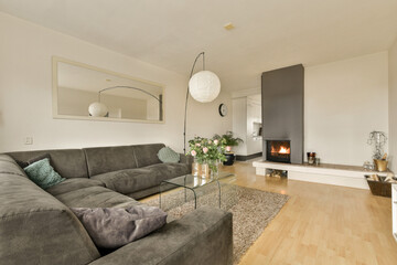 a living room with couches and a fire place in the middle of the room, there is a large mirror on the wall