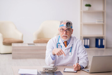 Old male doctor otologist working in the clinic