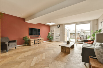 a living room with red walls and wood flooring in the center of the room, there is a tv on the wall