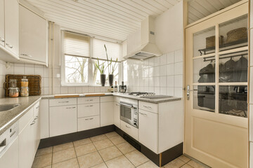 a kitchen with white cabinets and black counter tops on the counters in front of the sink is open to the door