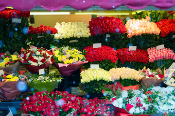 Colorful roses bouquet display in front of flower shop. Flower arrangements for sale at local market. Flowers on sale before mother day, 8 march.