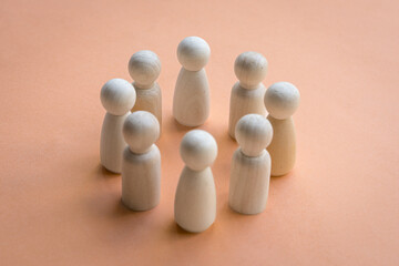Wooden dolls standing in a circle facing each other. Team decision or working together concept.