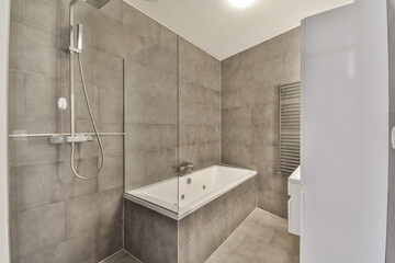 a bathroom with a sink and shower stall in the corner next to the bathtub on the right is an open door