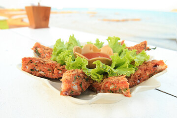 Fried fish patty is Thai food on a white table and sea view. Close-up, selective focus