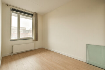 an empty room with wood flooring and white paint on the walls, there is a heater in the corner