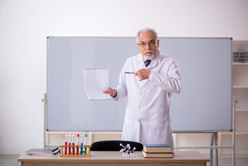 Fototapeta premium Old male chemistry teacher in the classroom