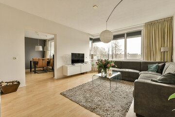 a living room with couches, chairs and a television set in the center of the room there is a large window