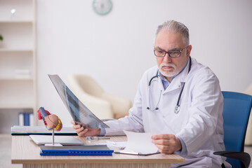 Obraz premium Old male doctor radiologist working at the hospital