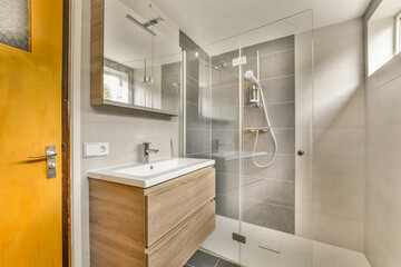 a bathroom with a yellow door and white tiles on the wall behind it is a wooden vanity, sink and...