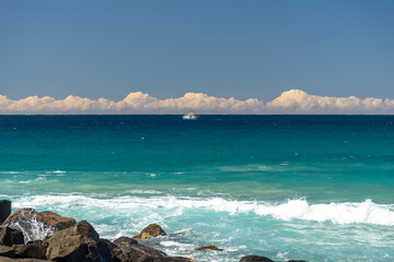 View out to sea from Point Danger on the Queensland New South Wales border, featuring fishing trawler in the distance and white clouds on the horizon.