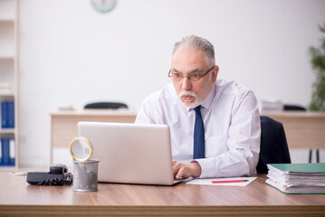 Old male employee working in the office