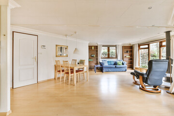 an empty living room with wood flooring and white walls, there is a rocking chair in the middle of the room