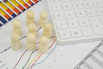 Financial documents, modern calculator and group of wooden people figures. Concept of research, statistics and sociology.