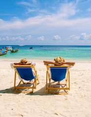 beach chairs at the beach of Koh Kradan island in Thailand couple men and woman relax on the beach