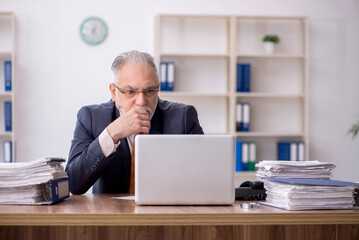 Old male employee working in the office