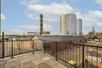an outside area with buildings in the background and people walking on the sidewalk, looking out to the city below