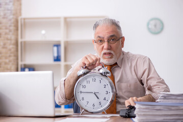 Old male employee in time management concept