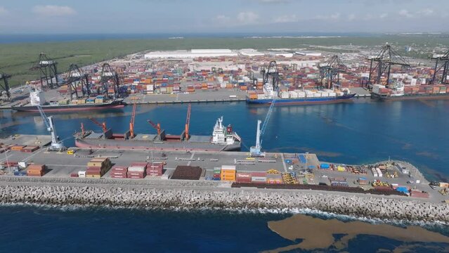 Aerial view of Multimodal Caucedo Port with industrial cranes and container for cargo operation - Boca Chica, Dominican Republic 
