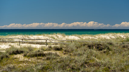 View across sand dunes to the ocean at Kirra Beach, Queensland, Australia. Clouds on the horizon. 