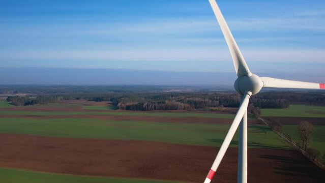 Aerial view close-up of a wind turbine that generates electricity on sunny day