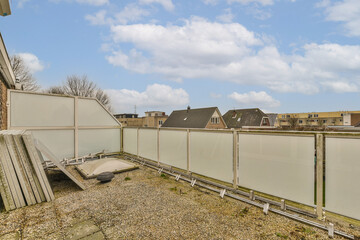 an outside area with a fence and some buildings in the background, as seen on a clear blue sky day