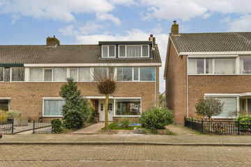some houses that are in front of each other buildings and one has a car parked on the street next to it