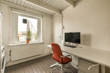 a room with a desk, chair and television on the wall in front of a window that looks out onto the street