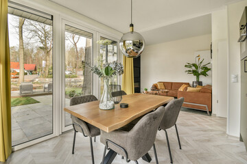 a dining table and chairs in a room with sliding glass doors looking out onto the backyard patio area that overlooks