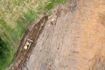 yellow bulldozer carries out excavation work on construction site. birds eyes view.