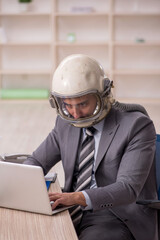 Young male employee wearing spacesuit in the office