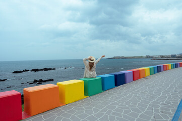 Lady tourist travel at Dodu-dong Rainbow Coastal Road in Jeju Island, Korea.