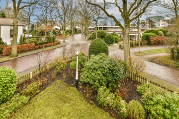 a residential area with trees and bushes in the fore - image was taken from an aerial view on a sunny day