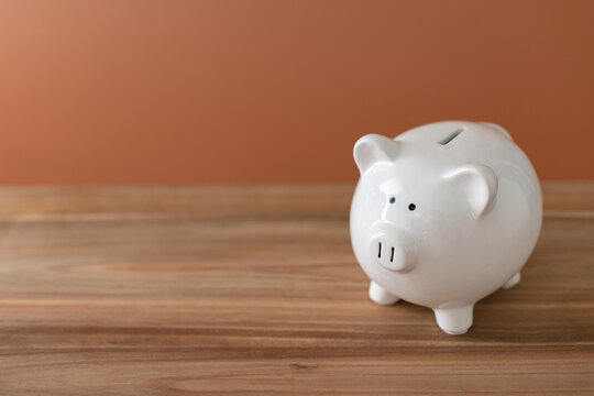 Piggy bank on brown wood  surface. Financial concept with blank space for text or image.