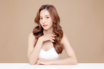 Young Asian beauty woman curly long hair with korean makeup style on face and perfect skin on isolated beige background. Facial treatment, Cosmetology, plastic surgery. - obrazy, fototapety, plakaty