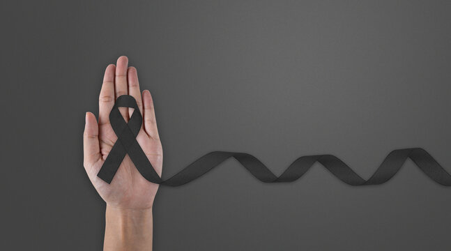 Hand hold black ribbon on background. Mourning is the grieving process. Melanoma and Skin Cancer Awareness Calligraphy Poster Design. Realistic Black Ribbon. - Powered by Adobe