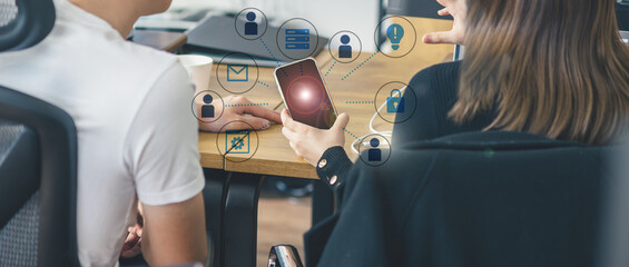 オフィスでのビジネスシーン、スマホを手にコミュニケーションをとる男女、IT企業、モバイルネットワーク © Metro Hopper